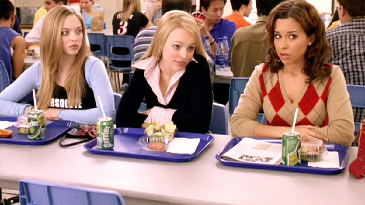 Three girls sitting at a high school cafeteria table